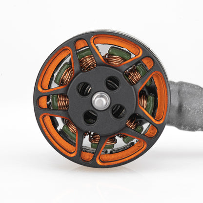 Top view of brushless motor showing orange spoke bell, mounting holes, and copper windings