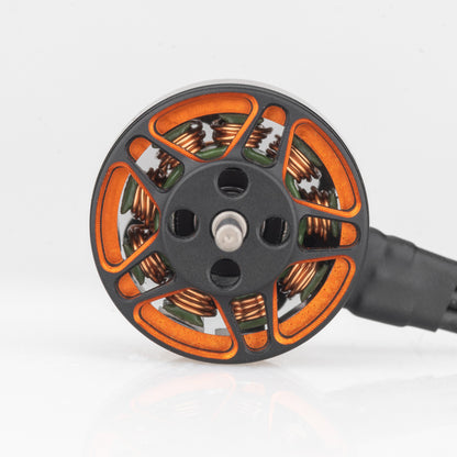 Top view of 1203 brushless motor bell showing orange cutouts, center shaft, and copper windings