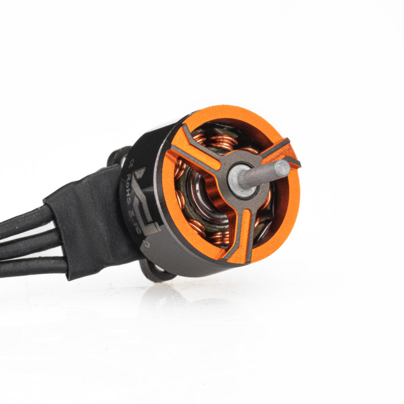 Motor front view showing orange bell, shaft, and three-wire lead bundle