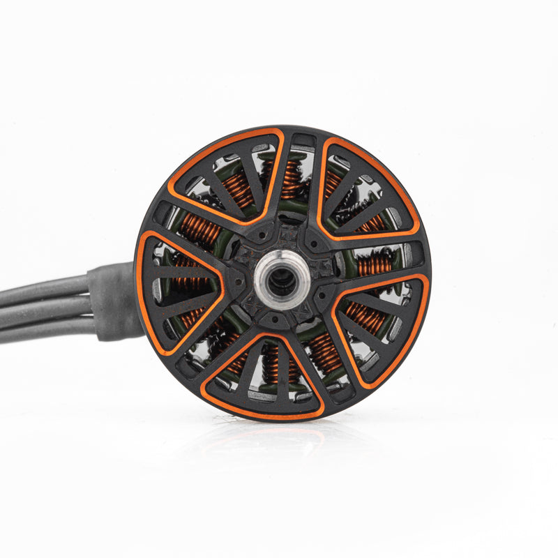 Top view of motor bell showing orange cutouts, copper windings, and center mounting hole with attached wires