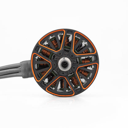 Top view of motor bell showing orange cutouts, copper windings, and center mounting hole with attached wires