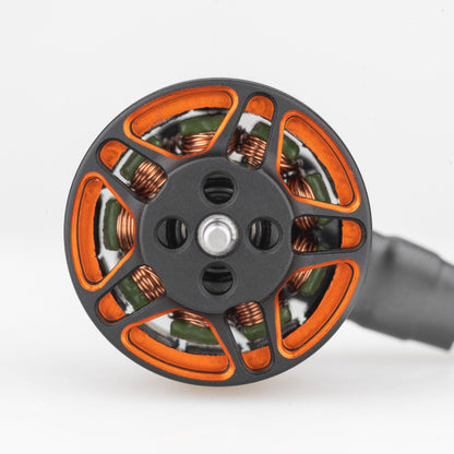 Top view of motor bell showing orange cutouts, copper windings, and center shaft mount holes