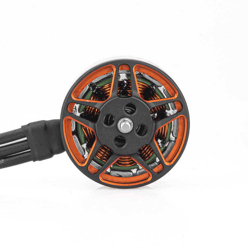 Top view of brushless motor showing orange stator windings, spoke-style bell, and attached wires