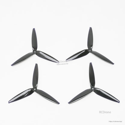 Set of four black tri-blade propellers for ATOMRC Beluga fixed wing, laid out on white background