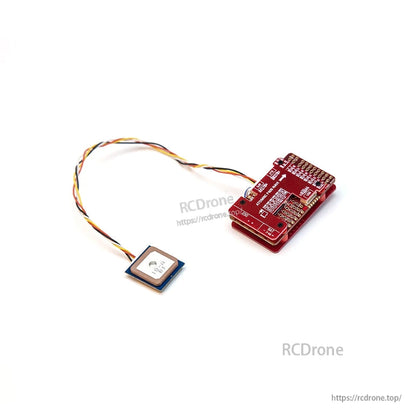Flight controller board with wired square GPS module attached, angled view of ports and pads