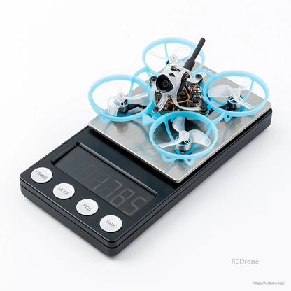 BETAFPV micro whoop FPV quadcopter with blue ducted prop guards sitting on a digital scale
