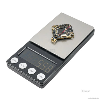 Flight controller board on a digital scale with the display reading 6.60