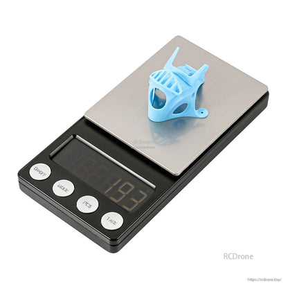 Micro camera canopy shown on a digital scale for weight reference, blue version