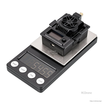 Micro TX V2 transmitter module on a digital scale showing weight measurement