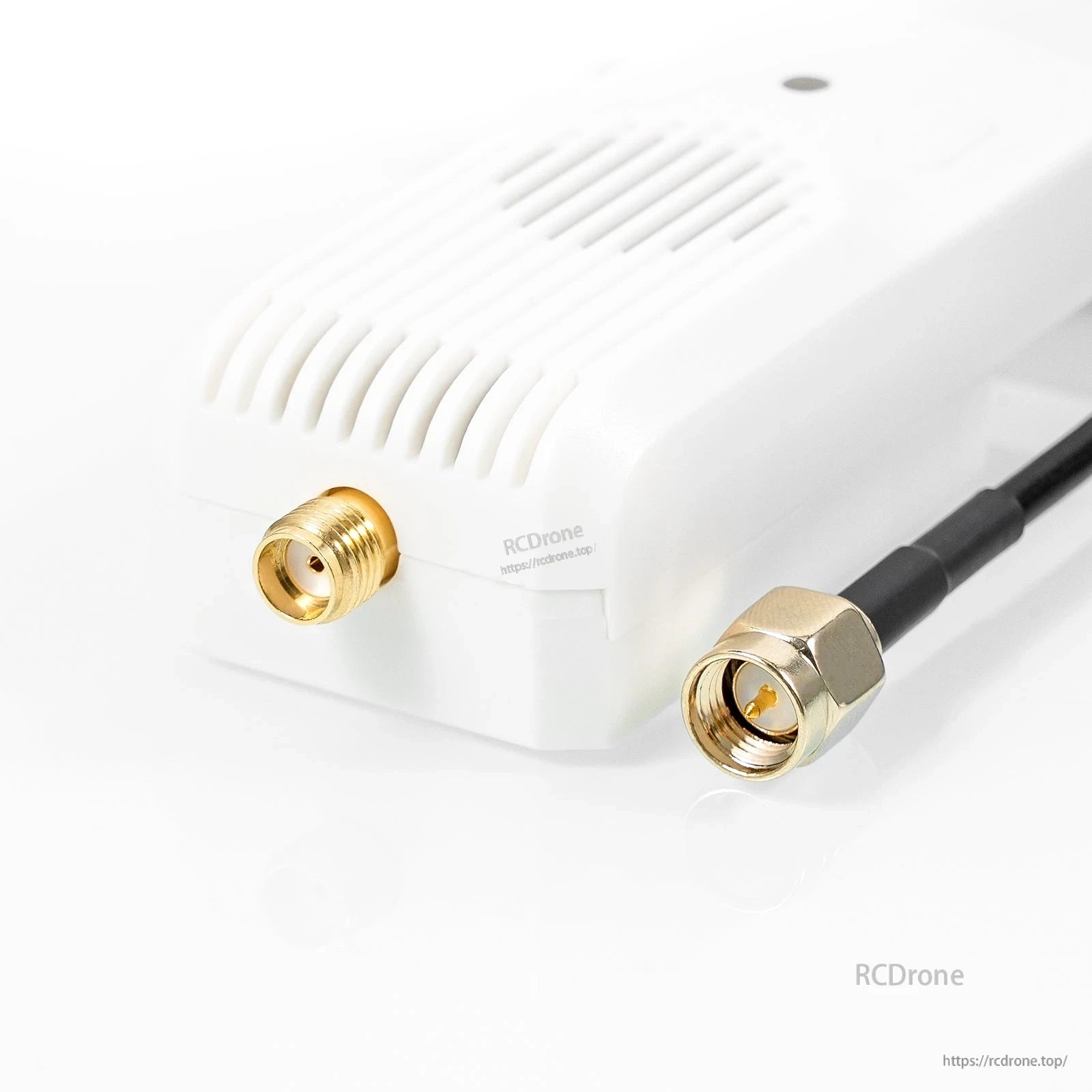Antenna port detail with coax pigtail connector beside the vented module housing, angled close-up