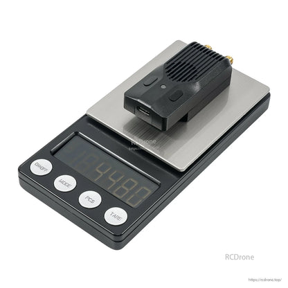Module placed on a digital scale platform to show compact size and weight reference
