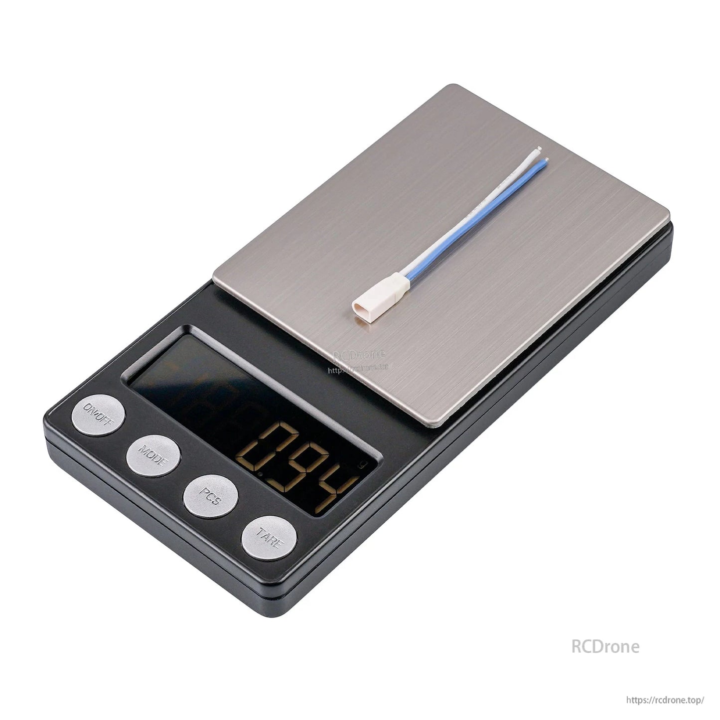 Short cable with white plug on digital scale reading 0.94 g, close-up weight view
