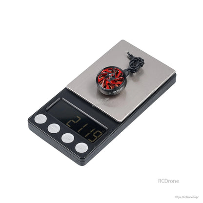 Brushless motor on digital scale showing 21.15 g weight, red bell design and wires coiled