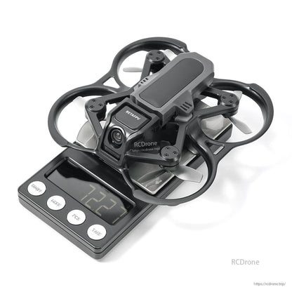 BetaFPV ducted FPV drone on a digital scale reading 232 g, with front camera and four prop guards