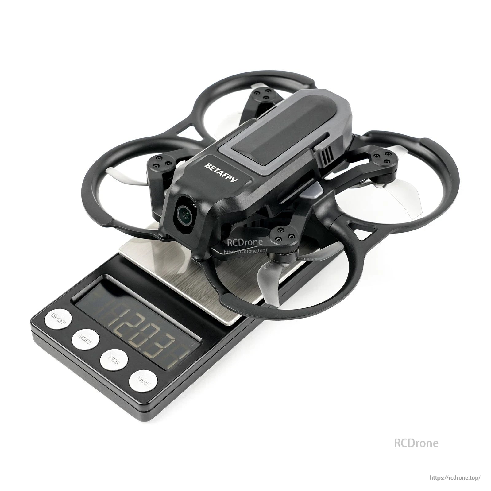 BetaFPV ducted cinewhoop drone with front camera and battery sitting on a digital scale reading 120.3 g