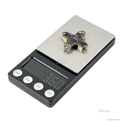 Flight controller placed on digital pocket scale, side angle showing underside connectors on platform