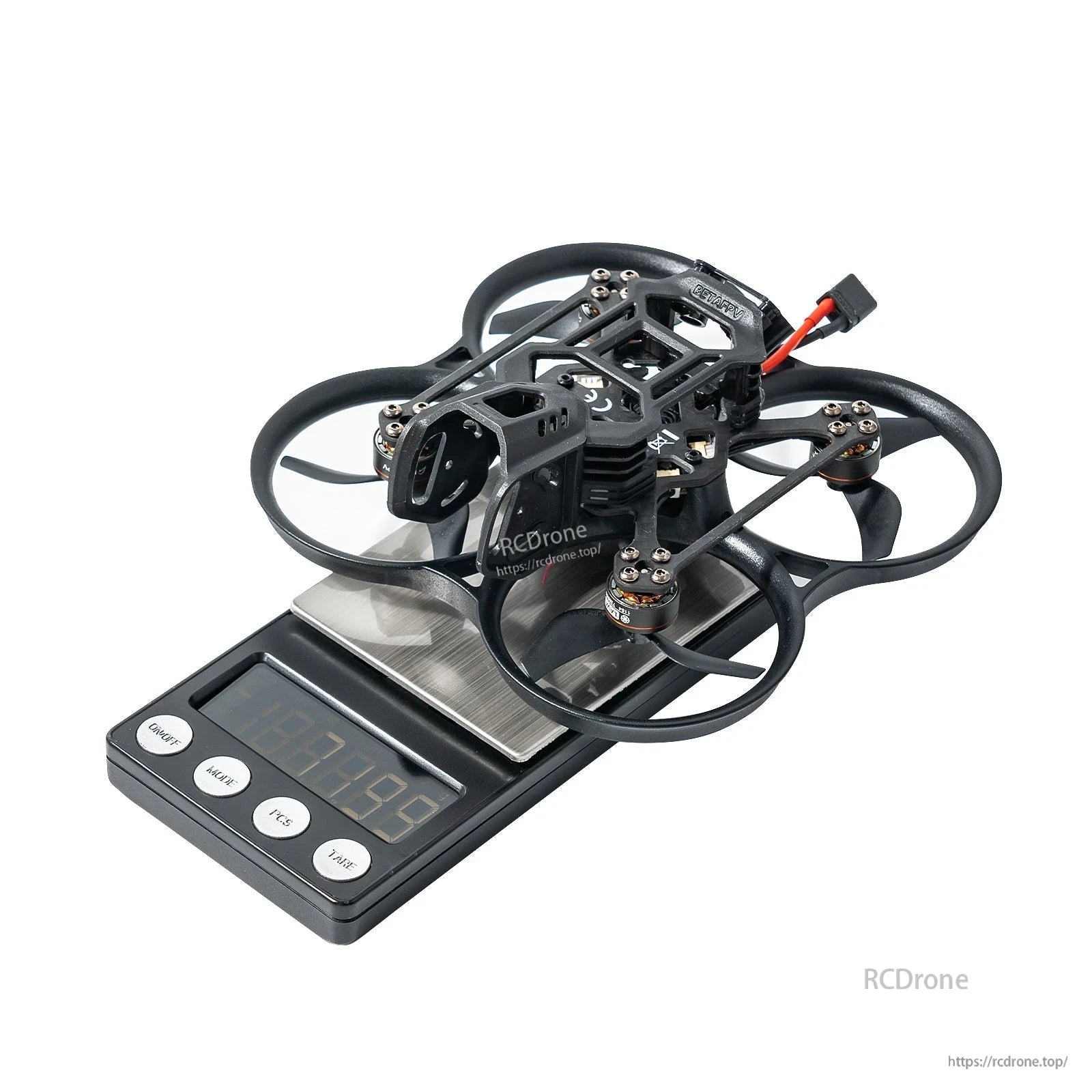 BetaFPV ducted cinewhoop quadcopter on a digital scale, showing compact frame with prop guards and battery lead