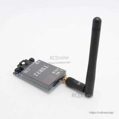 TS832 transmitter side angle with antenna attached, showing control buttons and compact module shape