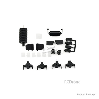 Replacement button set and small plastic parts laid out for a radio controller, assorted pads and caps