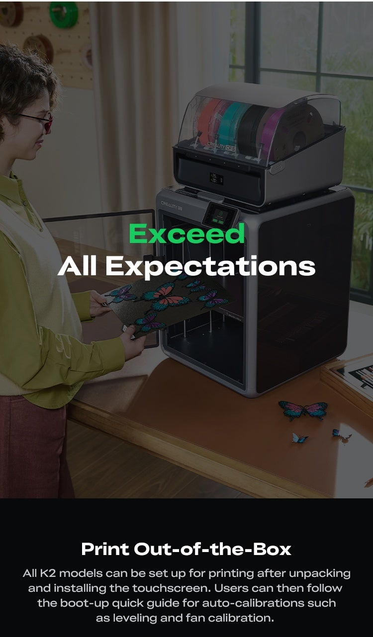 Creality K2 Combo enclosed 3D printer on a desk, with a user removing a build plate holding colorful butterfly prints
