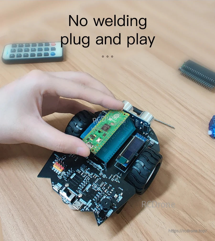 Hand installing a microcontroller board on a small two-wheel robot car chassis with plug-and-play wiring