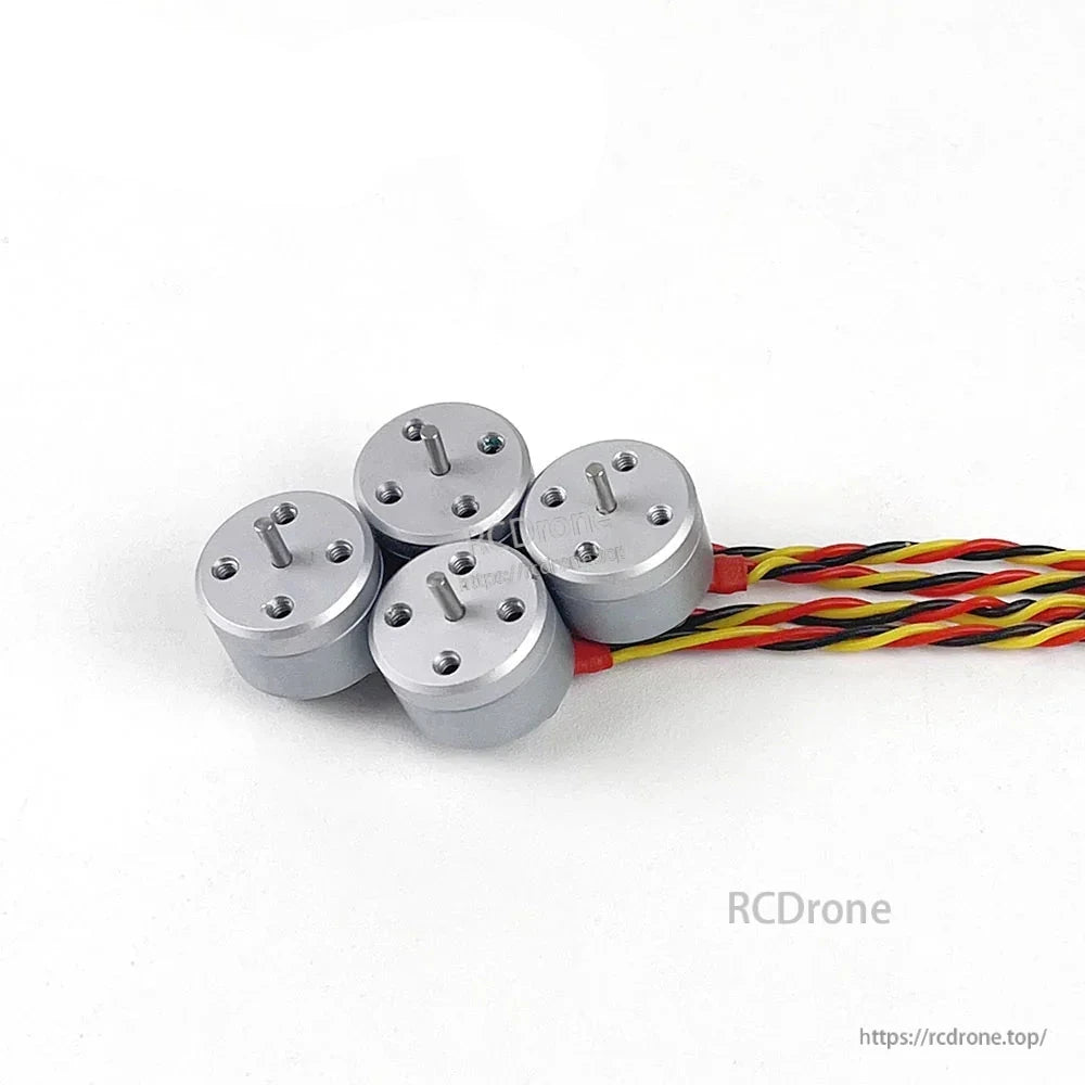 Set of four micro brushless motors with twisted lead wires grouped together on white background