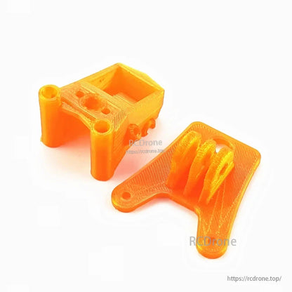 Orange 3D-printed FPV camera mount and bracket pieces included with the Darwin 129 frame kit