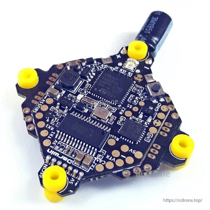 Angled close-up of F411 whoop AIO FC/ESC board showing solder pads and components