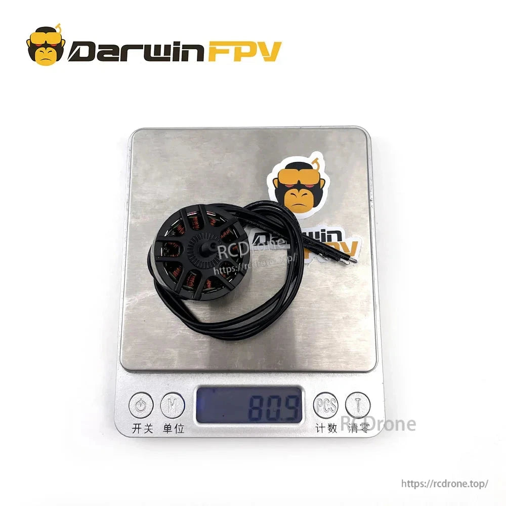 Motor on digital scale showing weight 80.9 g, with attached lead wires coiled on platform