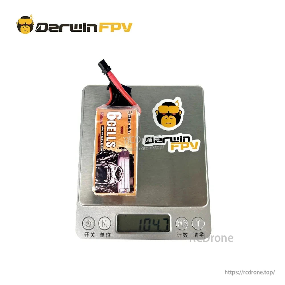 DarwinFPV 6S 650mAh LiPo battery on digital scale showing 104.7 g weight reading