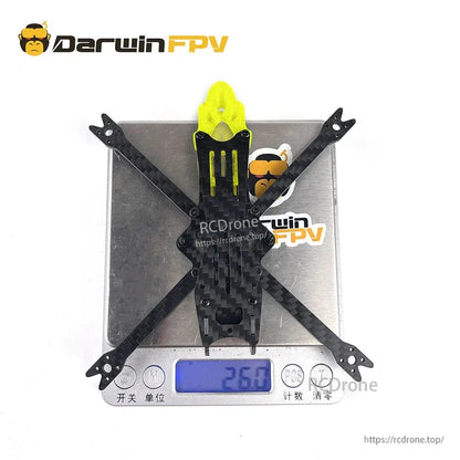 Assembled BabyApe V2 carbon frame on digital scale showing 26.0 g weight display