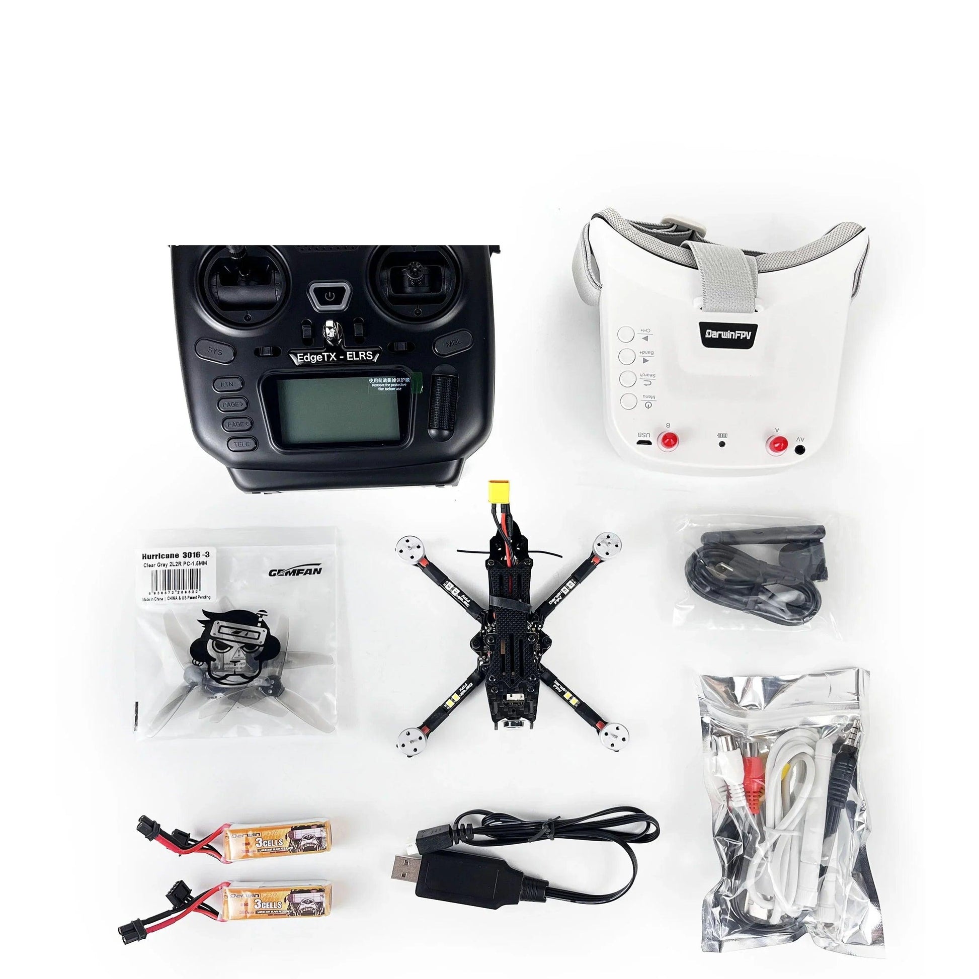 DarwinFPV RTF FPV drone kit flat lay with radio transmitter, FPV goggles, quadcopter, batteries and cables