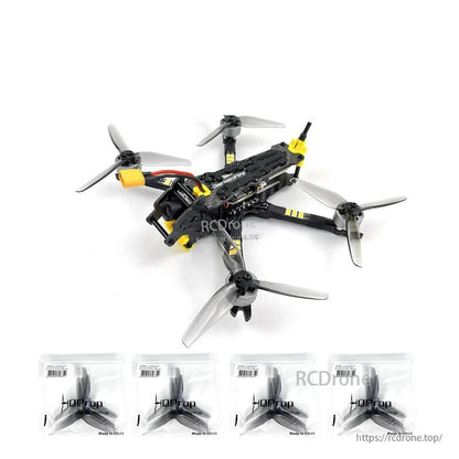 FPV drone shown with four spare propeller packs lined up underneath