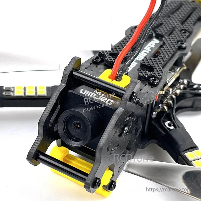 FPV camera close-up in carbon fiber cage with yellow mount and front bumper