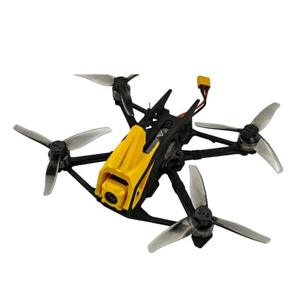 Angled top view of FPV quadcopter showing yellow canopy, carbon frame plates, and battery lead connector