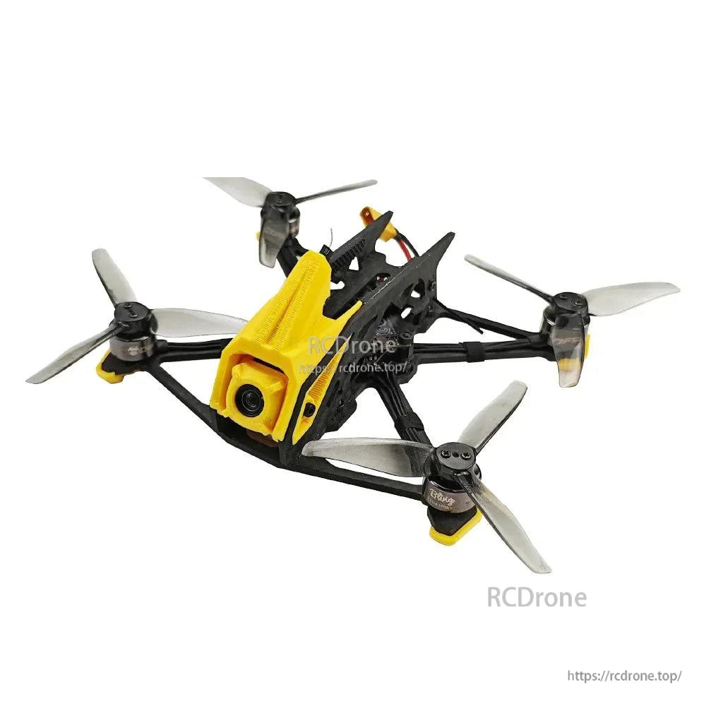 Angled front view of carbon frame FPV quadcopter with yellow canopy and four tri-blade propellers