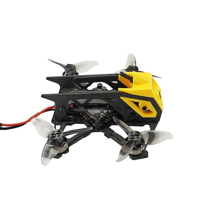 Side profile of micro FPV quadcopter showing carbon frame and yellow canopy, XT30 battery lead visible