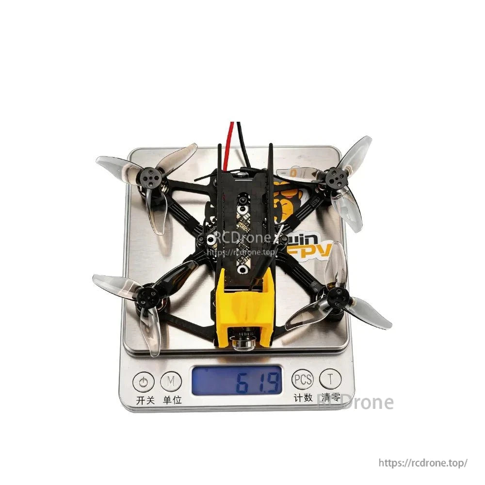 Top view of quadcopter on digital scale showing weight reading 61.9 g
