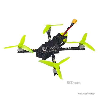 Low front angle of FPV quadcopter showing camera housing, carbon arms, and neon green props