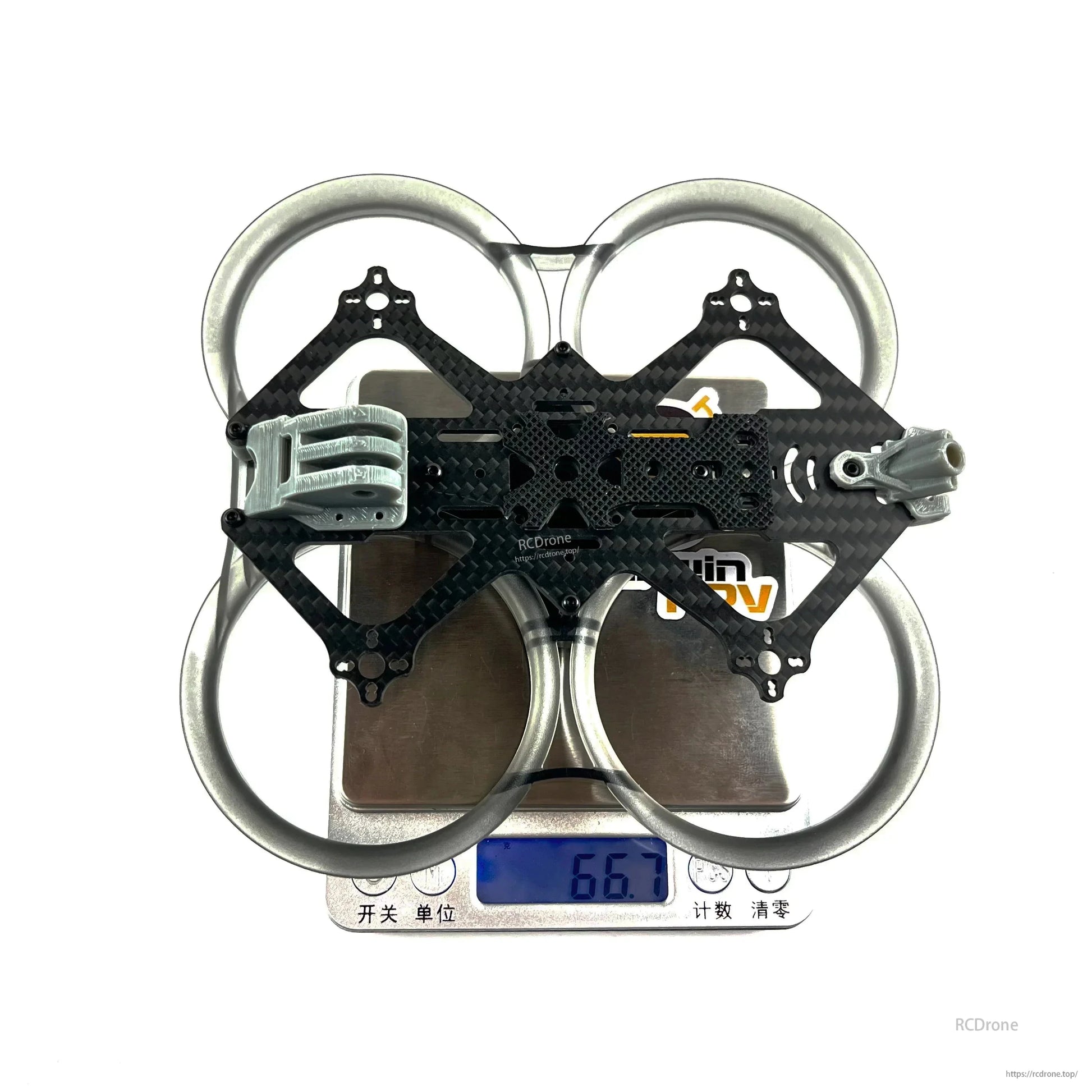 Assembled CineApe 25 whoop frame on digital scale showing 66.7 g weight reading