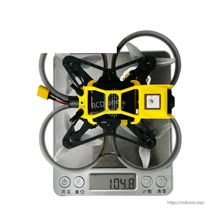 Bottom view on digital scale showing weight reading 104.8 g with square patch module visible