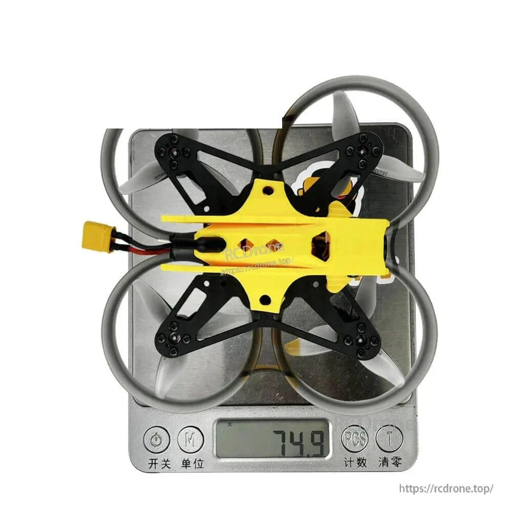 Top view on digital scale showing drone weight reading 74.9 g