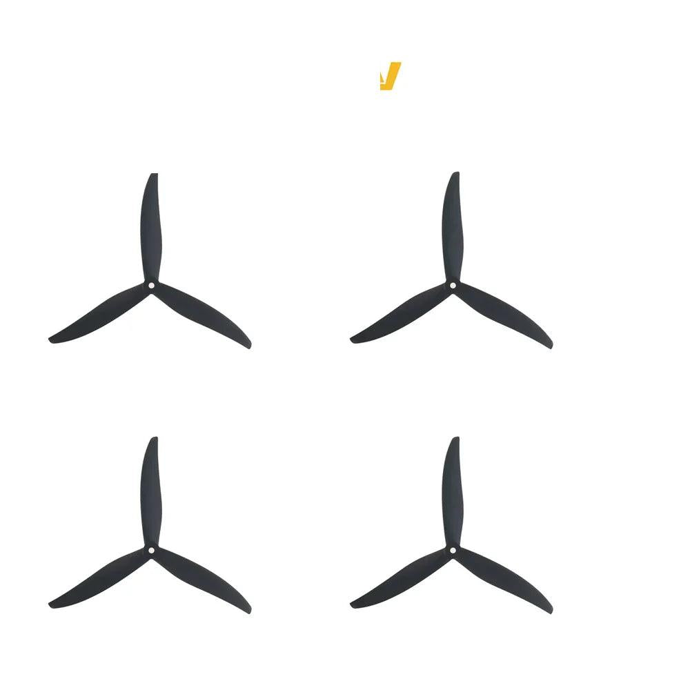Set of four black tri-blade propellers arranged in a 2x2 layout, top view