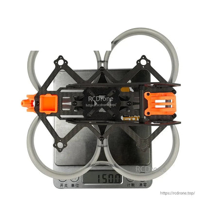 Assembled frame on digital scale showing 150.0 g weight reading, top view