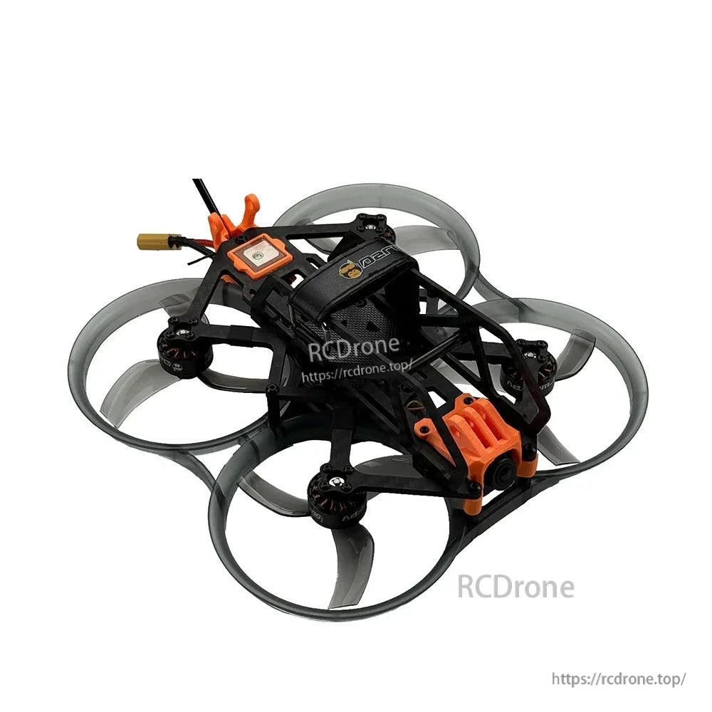 Three-quarter view showing carbon frame cage, orange camera mount, and rear wiring exit