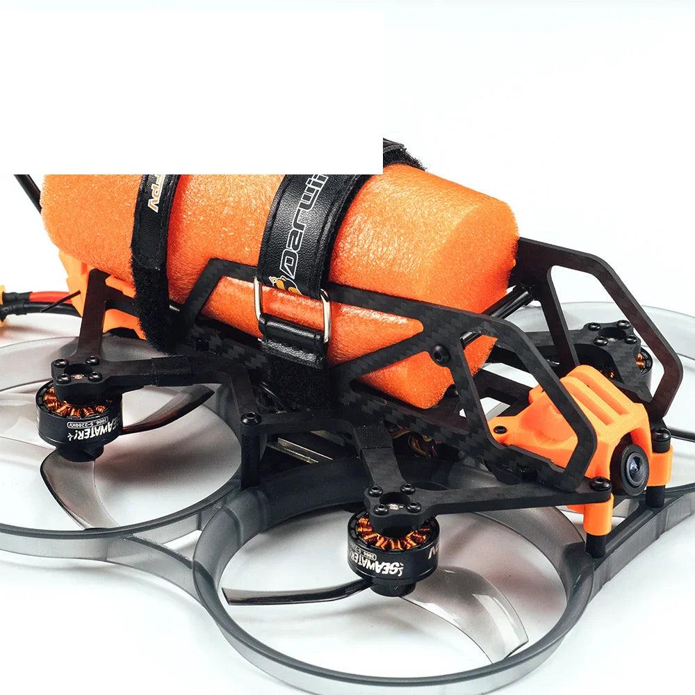 Side close-up of drone frame showing orange foam flotation block, battery straps, and ducted props