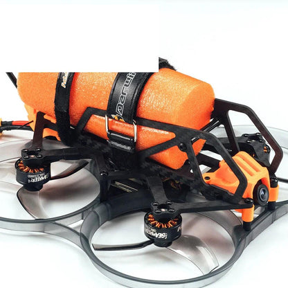 Side close-up of drone frame showing orange foam flotation block, battery straps, and ducted props