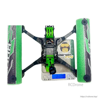 Top-down view of DarwinFPV drone on digital scale showing overall layout with green foam side guards