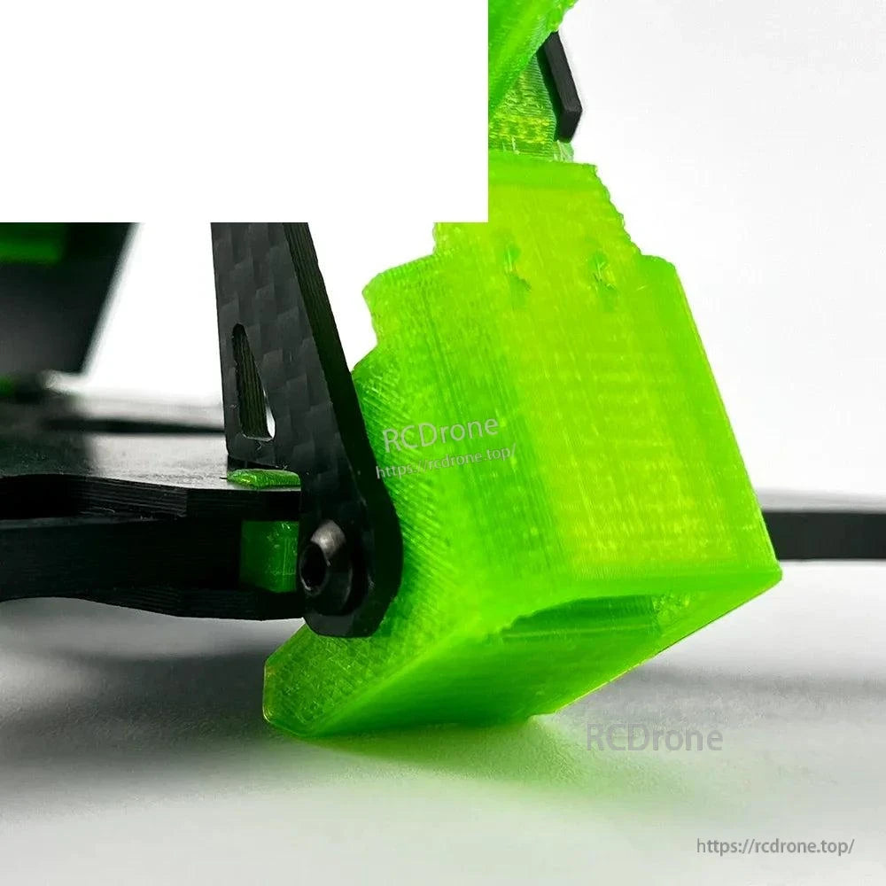 Close-up of green TPU rear skid/bumper mount attached to carbon fiber frame plate