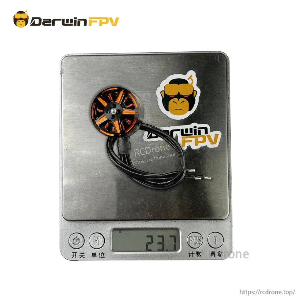 Motor on digital scale showing 23.7 g weight, with cable and connector visible